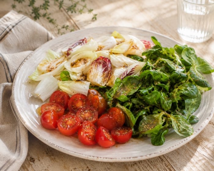 Summer salad with sesame honey dressing, cherry tomatoes, endives and mâche